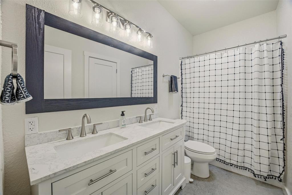 1525 North Bosley Road Santo, TX 76472 - Photo 26 of 40 a bathroom with a toilet sink and mirror