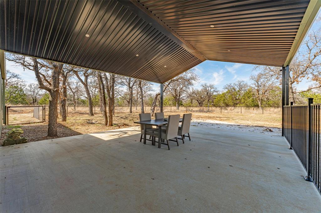1525 North Bosley Road Santo, TX 76472 - Photo 29 of 40 a view of a patio with table and chairs and floor to ceiling window