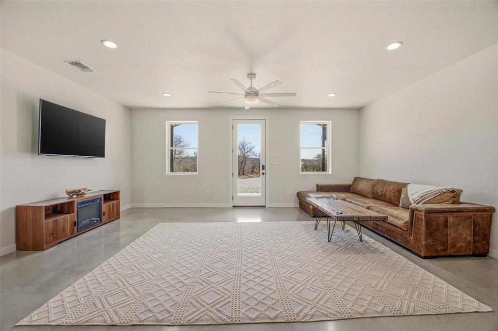 1525 North Bosley Road Santo, TX 76472 - Photo 9 of 40 a living room with furniture and a flat screen tv