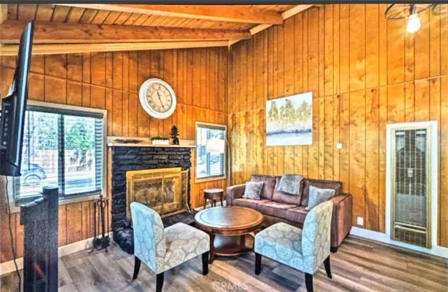 a living room with fireplace furniture and a large window