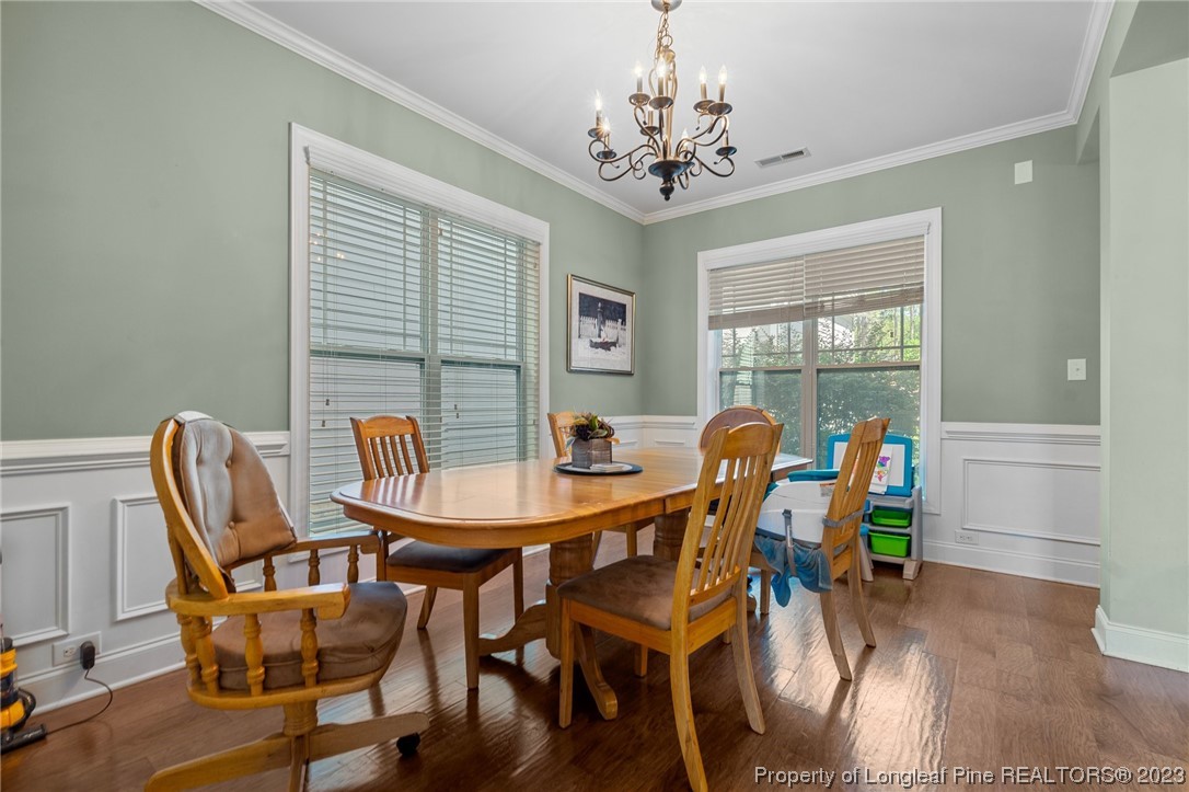 1365 Micahs Way North Spring Lake, NC 28390 - Photo 13 of 36 a view of a dining room with furniture wooden floor and chandelier