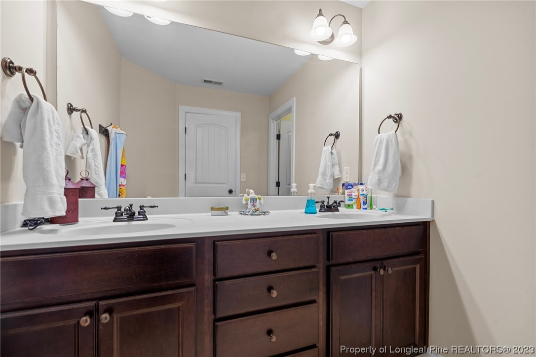 1365 Micahs Way North Spring Lake, NC 28390 - Photo 28 of 36 a bathroom with a double vanity sink and a mirror