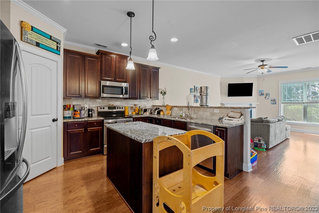 1365 Micahs Way North Spring Lake, NC 28390 - Photo 8 of 36 a kitchen with stainless steel appliances granite countertop a stove top oven a sink and a refrigerator