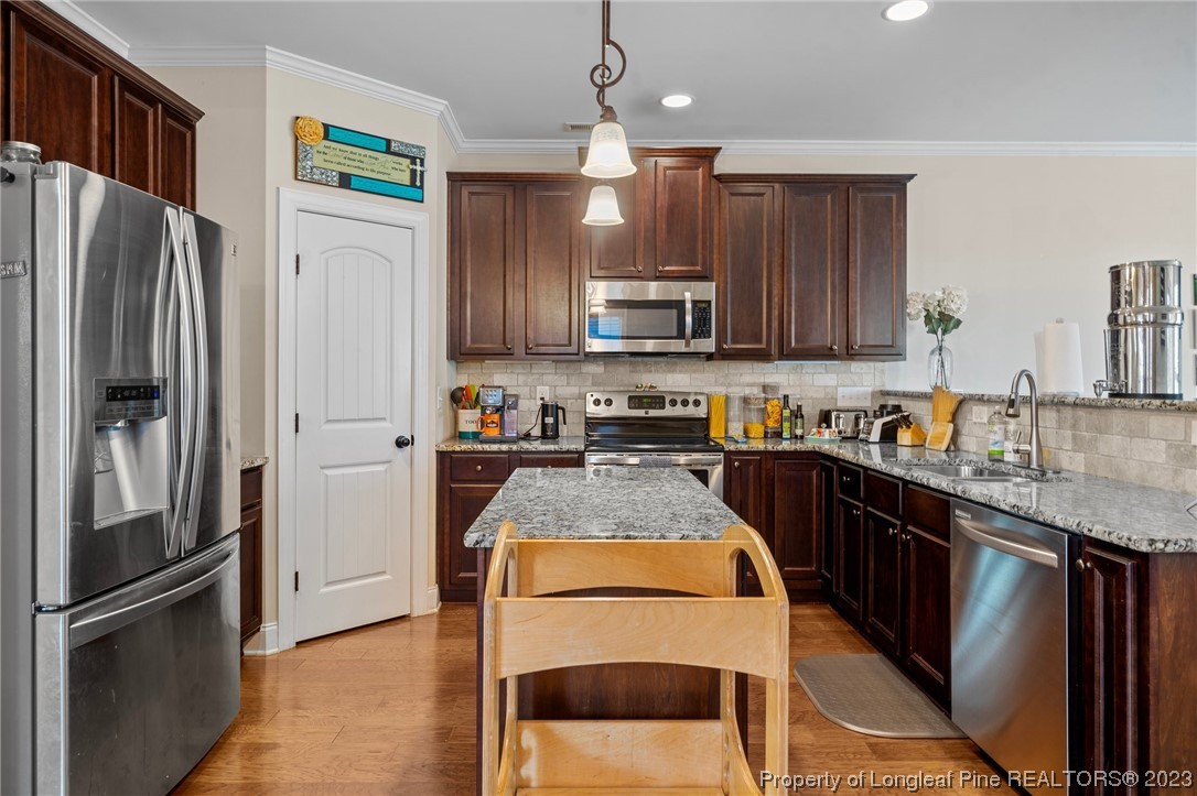 1365 Micahs Way North Spring Lake, NC 28390 - Photo 10 of 36 a kitchen with stainless steel appliances granite countertop a refrigerator a stove a sink and a microwave