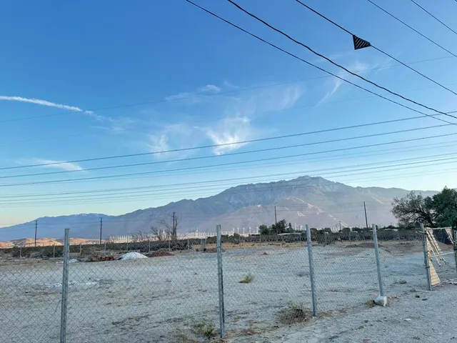 a view of a dry yard with wooden fence