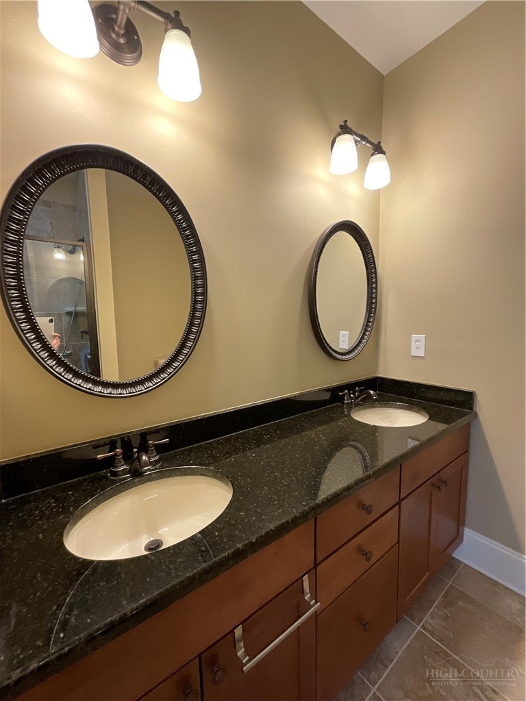 140 Gateway Drive, Unit 302 Boone, NC 28607 - Photo 23 of 30 a bathroom with a granite countertop double vanity and a mirror