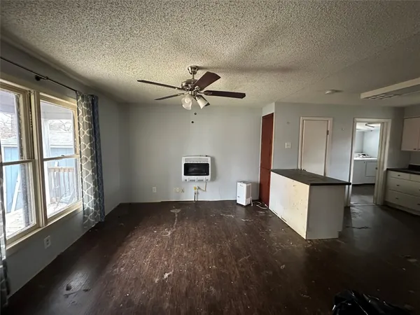 a view of a livingroom with a ceiling fan and wooden floor