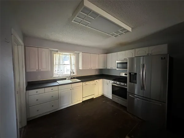 a kitchen with a refrigerator stove and sink