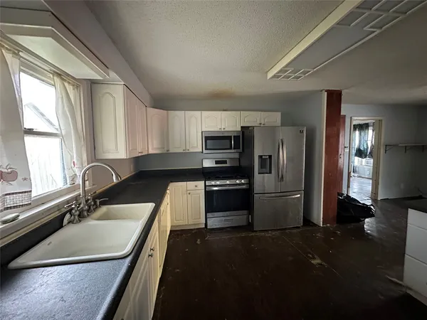 a kitchen with a refrigerator a sink a stove a microwave and cabinets