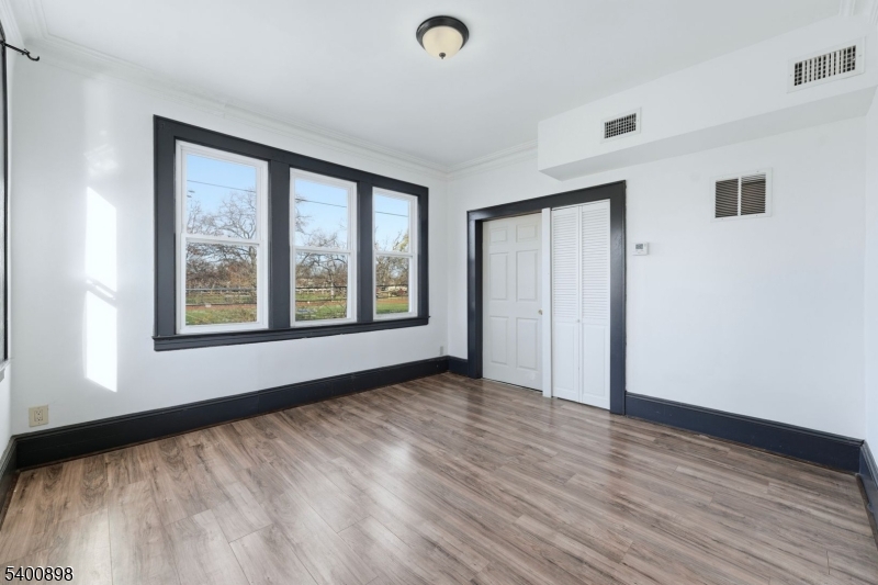 78 South Devine Street Newark, NJ 07106 - Photo 13 of 24 a view of an empty room with wooden floor and a window