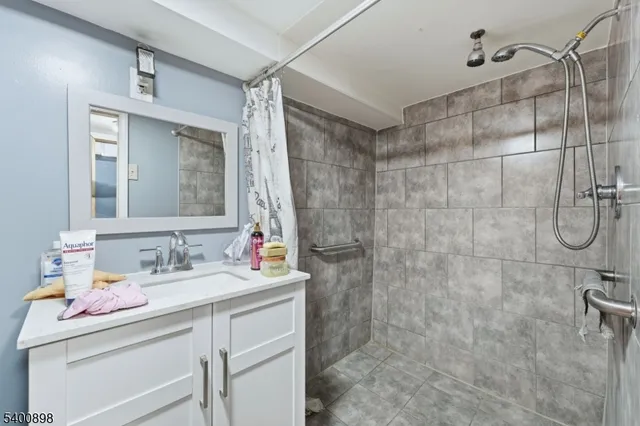 a bathroom with a sink vanity granite and shower