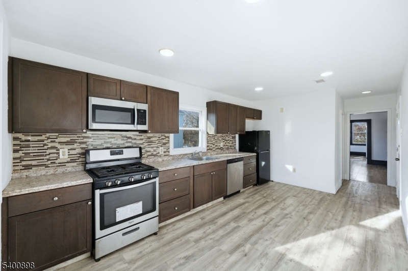 78 South Devine Street Newark, NJ 07106 - Photo 9 of 24 a kitchen with stainless steel appliances a stove sink microwave and cabinets