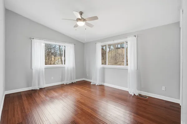a view of an empty room with wooden floor