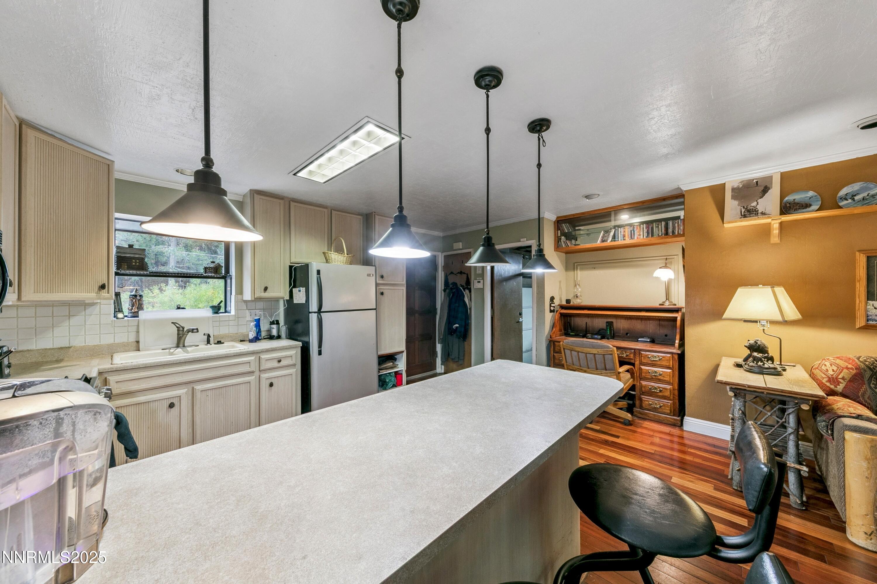 134 Aspen Way Stateline, NV 89449 - Photo 7 of 25 a kitchen with stainless steel appliances kitchen island granite countertop a sink a refrigerator a stove a kitchen island with a dining table and chairs