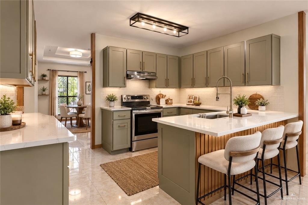 401 West Alberta Road Edinburg, TX 78539 - Photo 9 of 21 Kitchen featuring extensive cabinetry, white countertops, stainless steel appliances, and a central island with a built-in sink