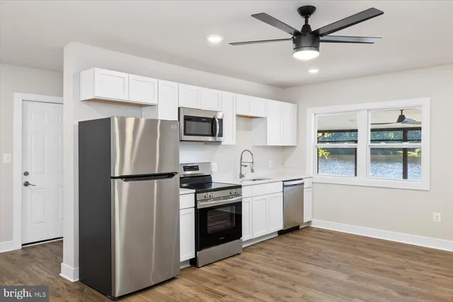 an empty room with wooden floor and a window