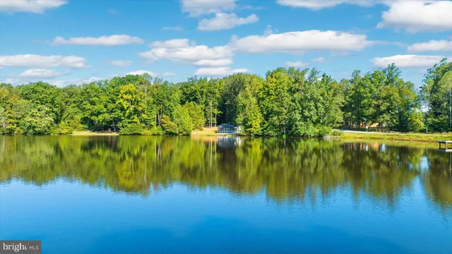 a view of an empty room with a large window with ceiling fan