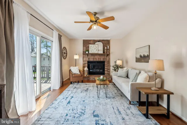 a living room with furniture a fireplace and a floor to ceiling window