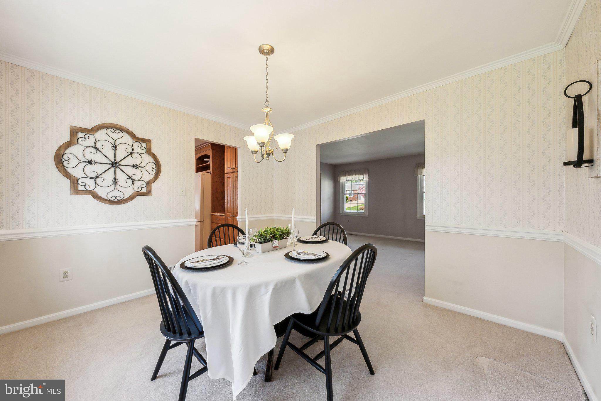 8312 Timber Brook Lane Springfield, VA 22153 - Photo 13 of 42 a view of a dining room with furniture a chandelier and wooden floor