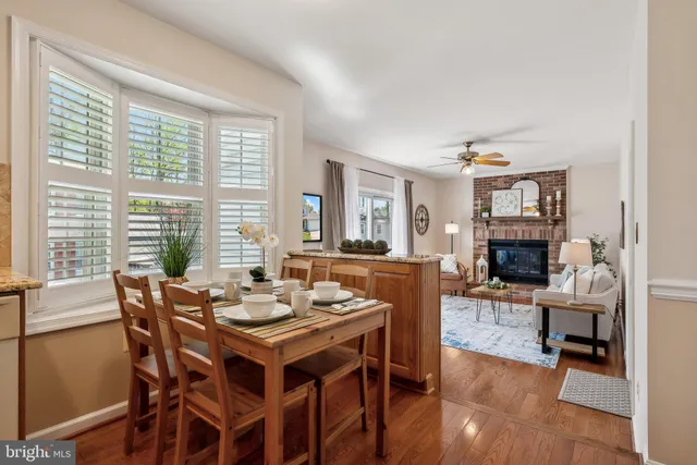 a kitchen with stainless steel appliances granite countertop a sink a stove a refrigerator and island with wooden floor