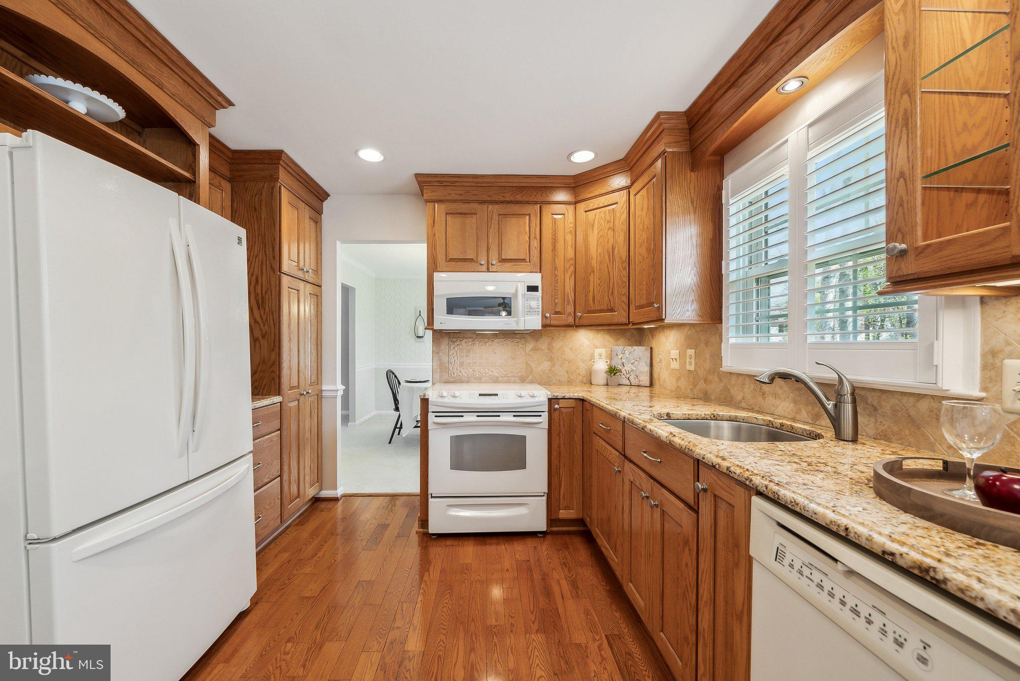 8312 Timber Brook Lane Springfield, VA 22153 - Photo 18 of 42 a kitchen with a sink a refrigerator and a stove top oven