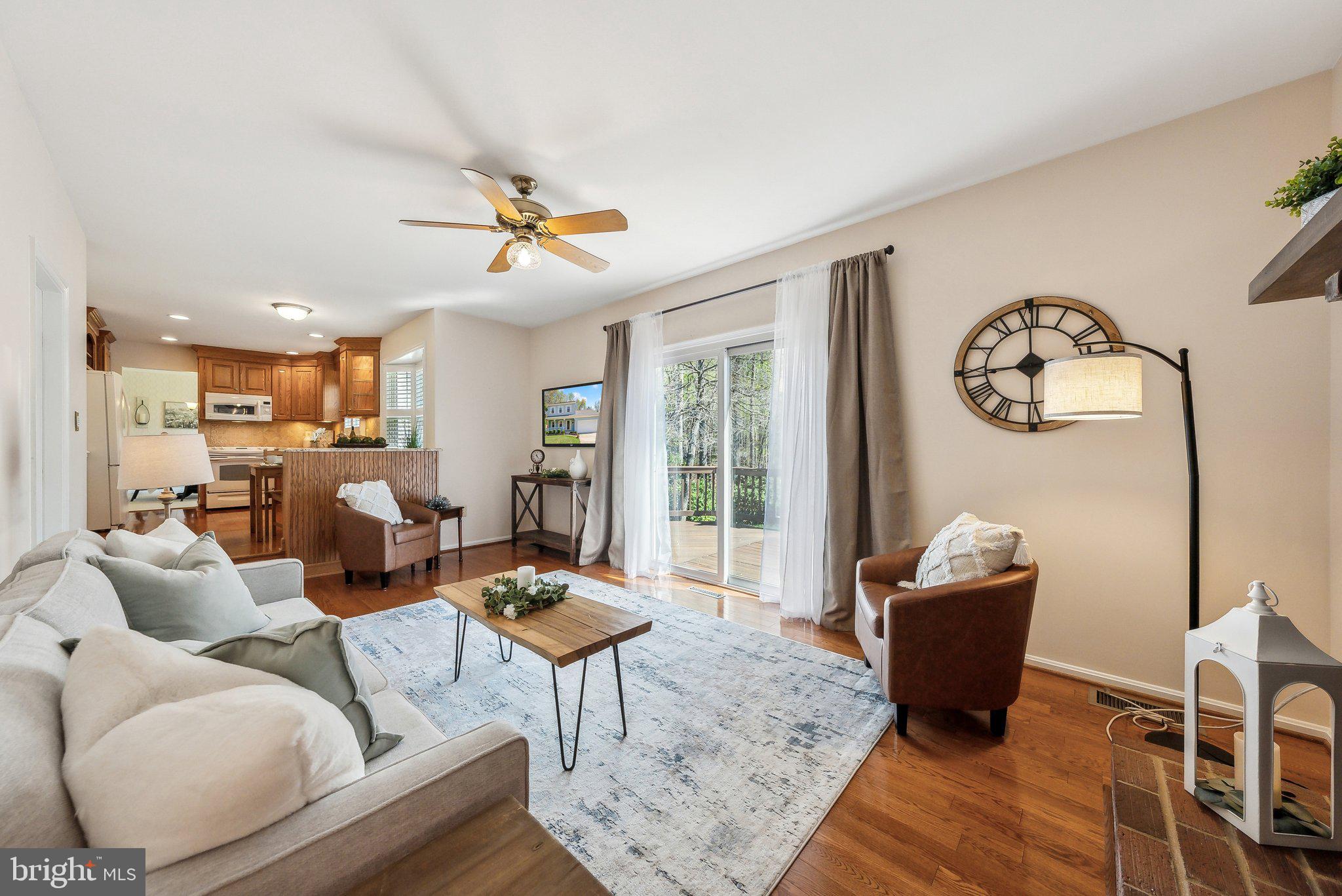 8312 Timber Brook Lane Springfield, VA 22153 - Photo 38 of 42 a living room with furniture a rug and a chandelier