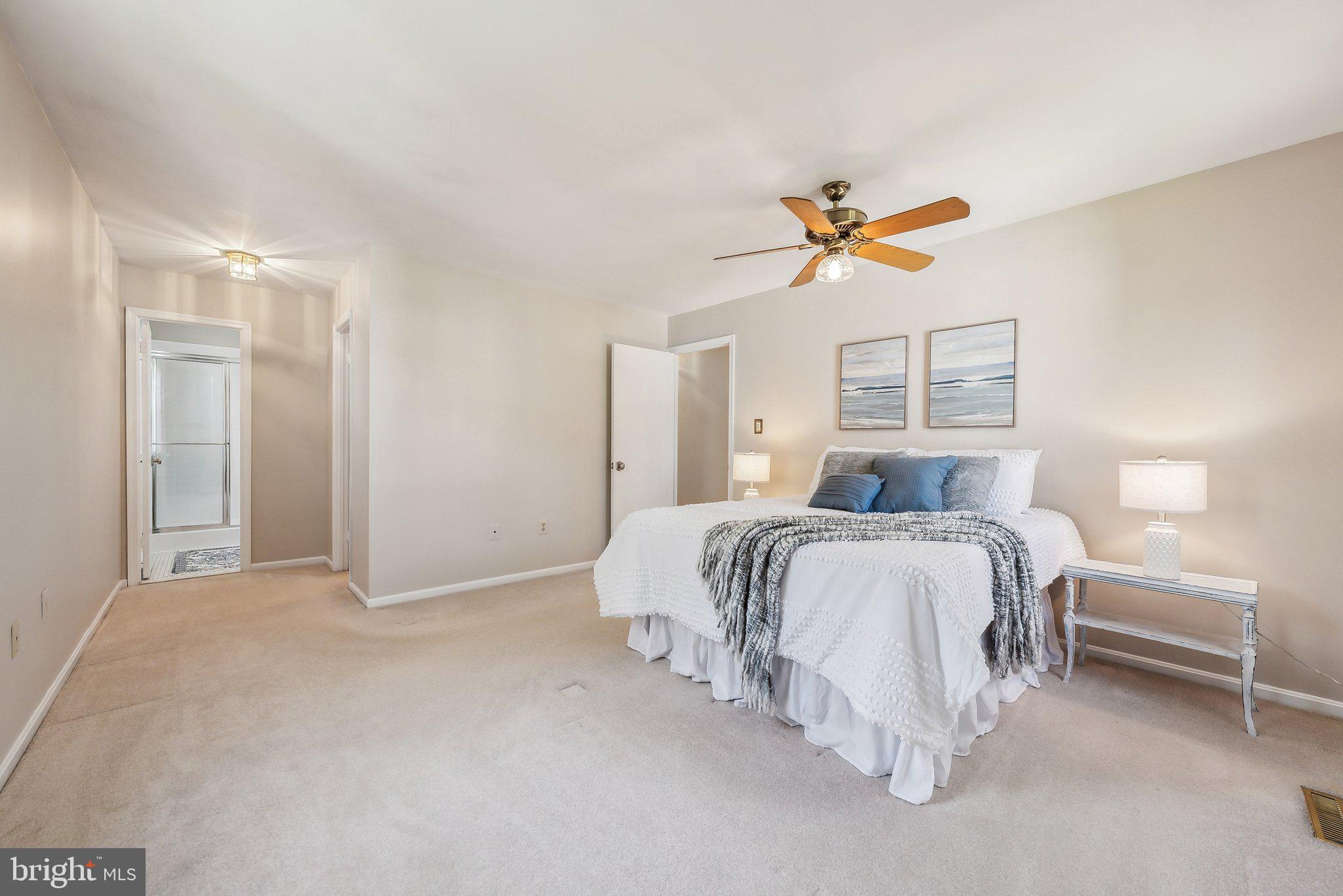 8312 Timber Brook Lane Springfield, VA 22153 - Photo 23 of 42 a spacious bedroom with a bed and a chandelier