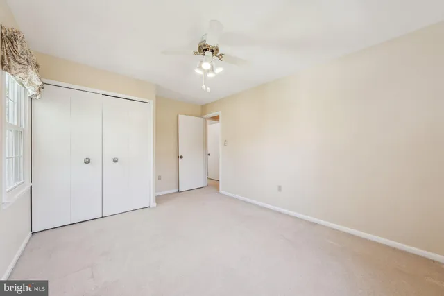 a view of an empty room with a ceiling fan