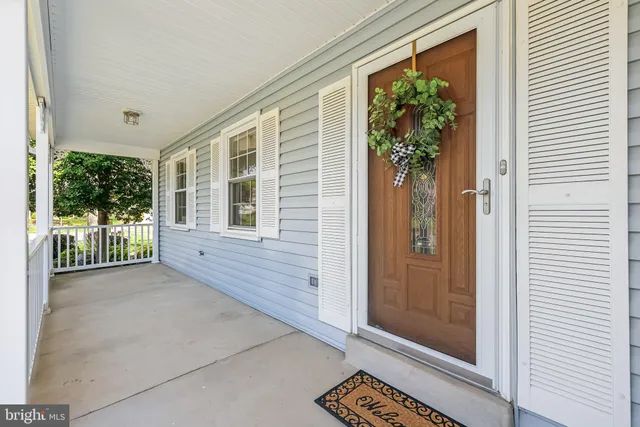 a view of a porch with a door and wooden floor