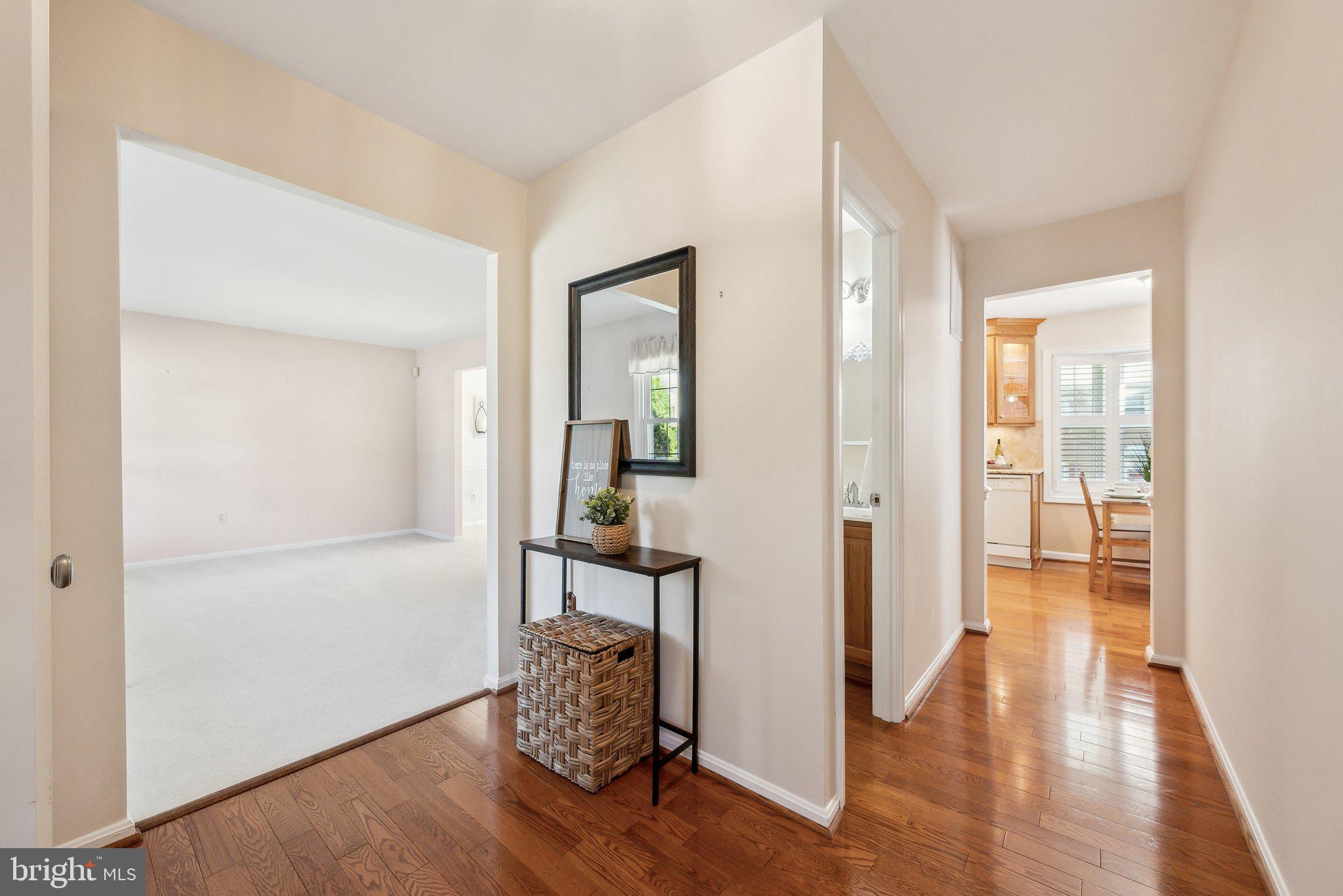 8312 Timber Brook Lane Springfield, VA 22153 - Photo 7 of 42 a view of a hallway with wooden floor and a livingroom