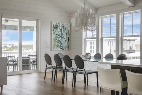 a kitchen with stainless steel appliances granite countertop a stove a sink dishwasher a dining table and chairs with wooden floor