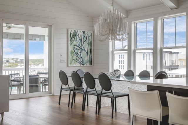 a kitchen with stainless steel appliances granite countertop a stove a sink dishwasher a dining table and chairs with wooden floor