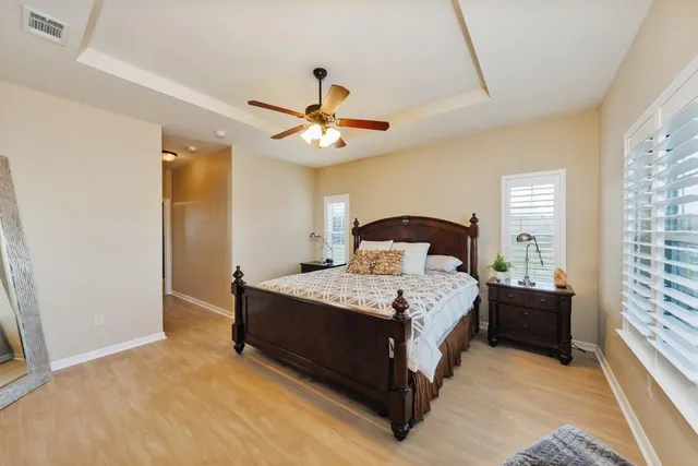 a bedroom with a bed chandelier and a window