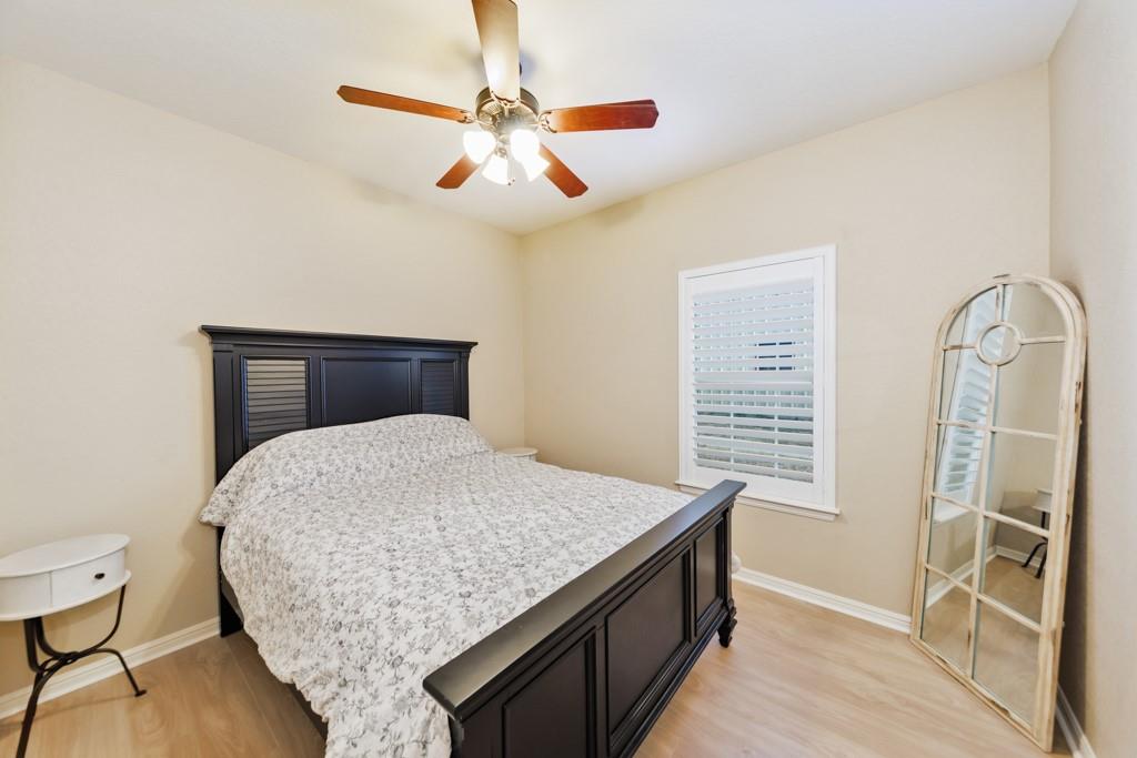 151 Conestoga Court Rhome, TX 76078 - Photo 13 of 38 a bedroom with a bed and wooden floor