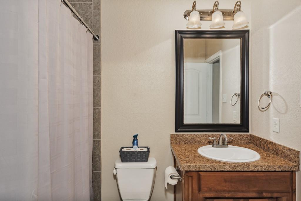 151 Conestoga Court Rhome, TX 76078 - Photo 17 of 38 a bathroom with a granite countertop sink and a mirror