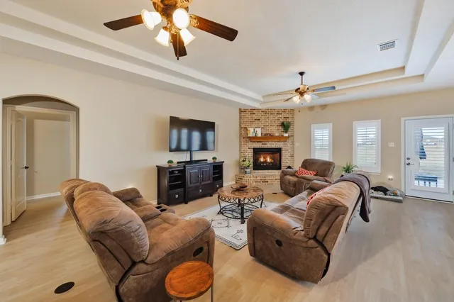 a living room with furniture a ceiling fan and a flat screen tv