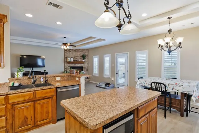 a kitchen with stainless steel appliances granite countertop counter space a sink cabinets and living room view