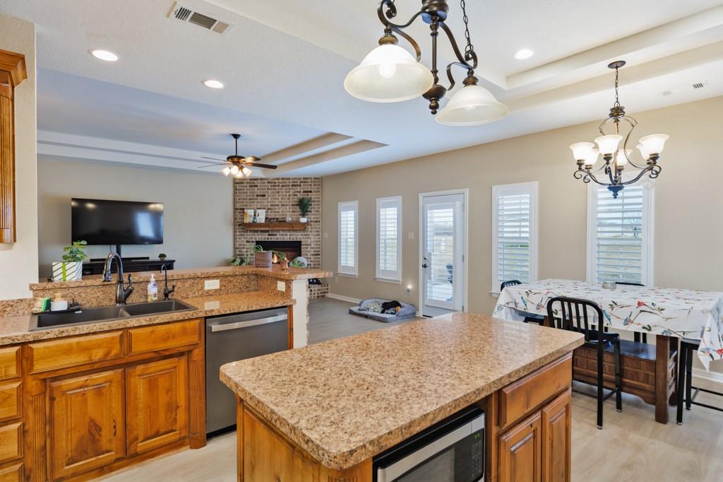151 Conestoga Court Rhome, TX 76078 - Photo 25 of 38 a kitchen with stainless steel appliances granite countertop counter space a sink cabinets and living room view