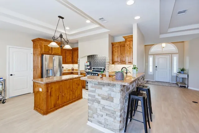a large kitchen with kitchen island a large counter space a sink appliances and cabinets