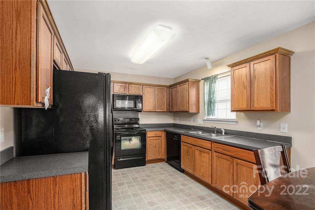 1222 Ben Livingston Road Charlotte, NC 28214 - Photo 14 of 32 a kitchen with stainless steel appliances granite countertop a refrigerator a sink dishwasher a stove and white countertops with wooden floor