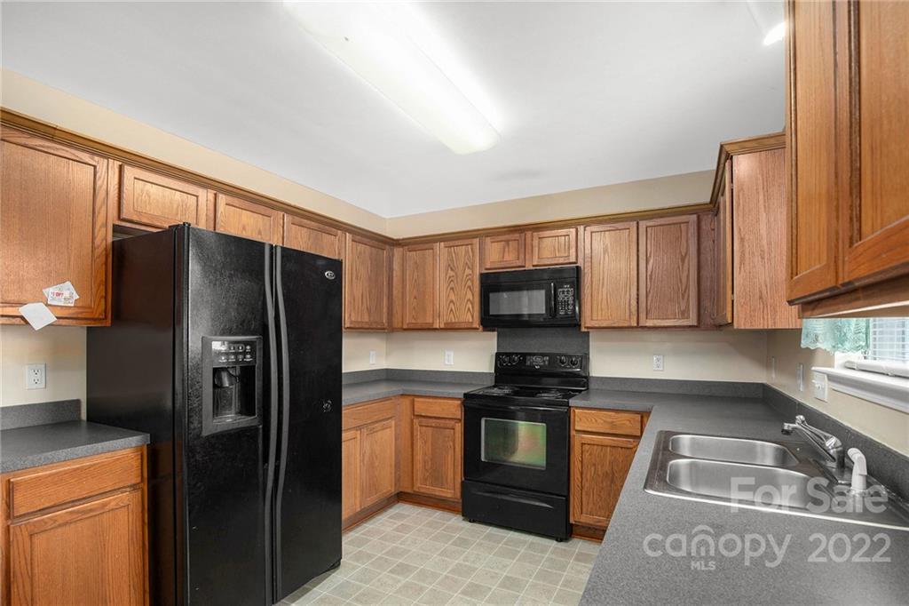 1222 Ben Livingston Road Charlotte, NC 28214 - Photo 15 of 32 a kitchen with stainless steel appliances granite countertop a refrigerator stove and sink
