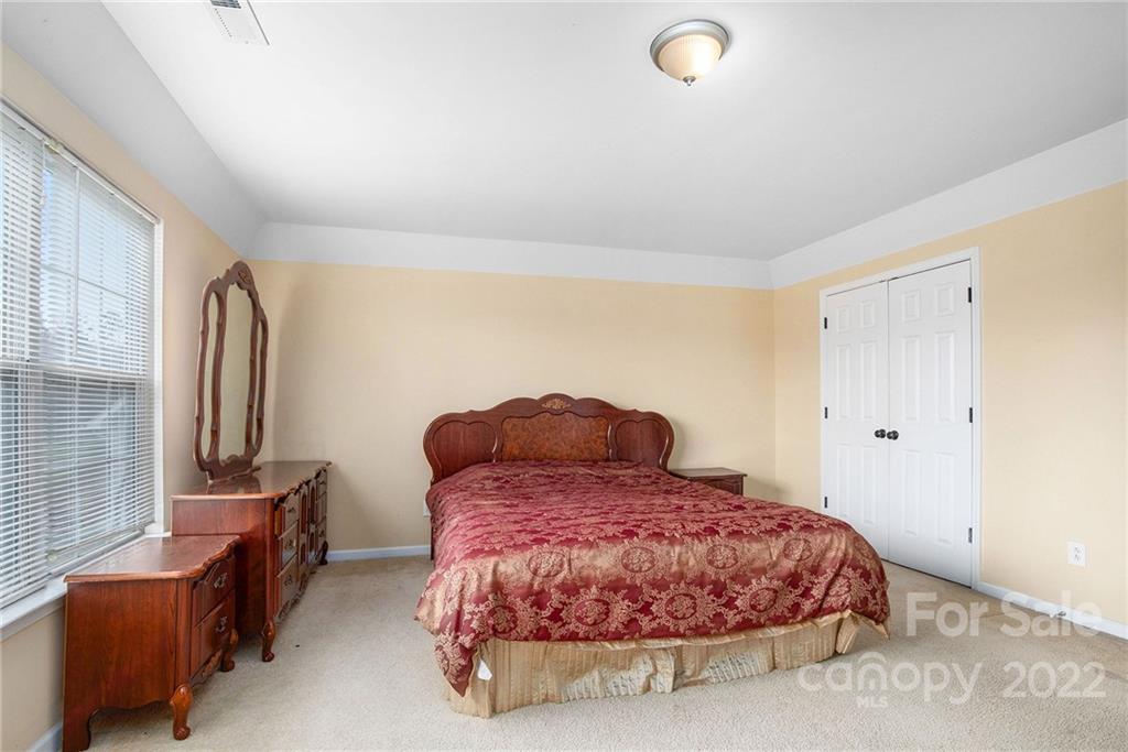 1222 Ben Livingston Road Charlotte, NC 28214 - Photo 18 of 32 a bedroom with a bed and wooden floor