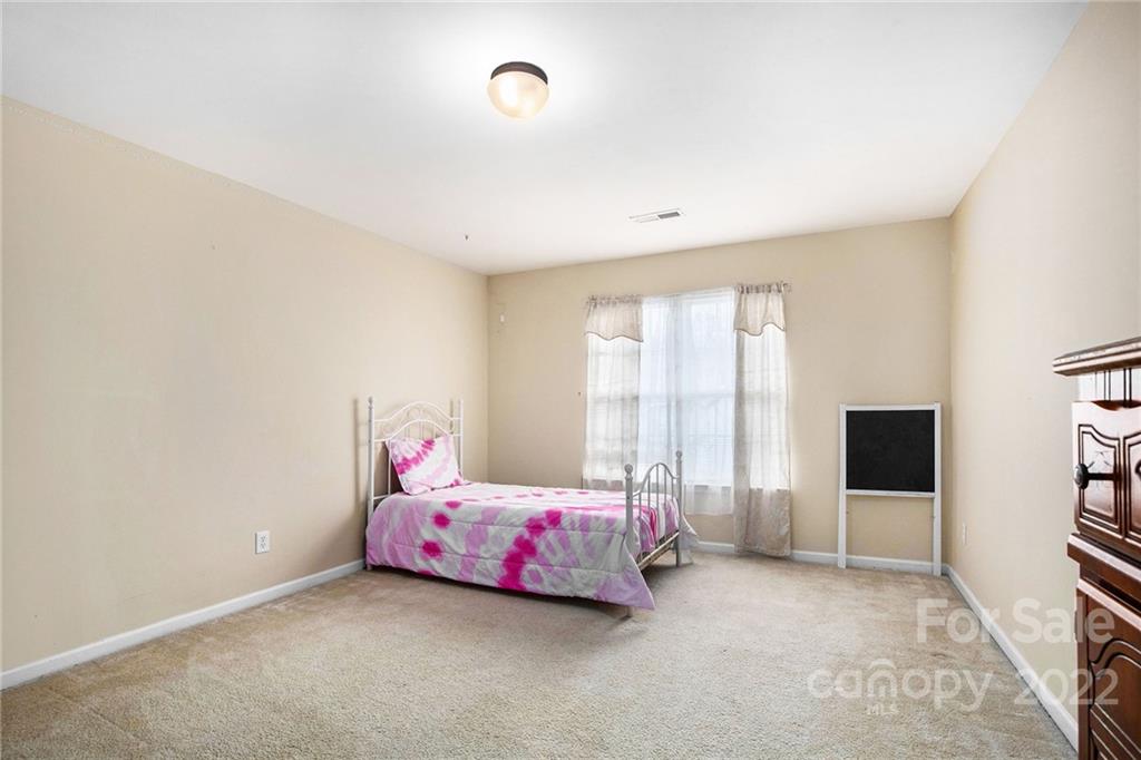 1222 Ben Livingston Road Charlotte, NC 28214 - Photo 22 of 32 a bedroom with a bed and flat screen tv