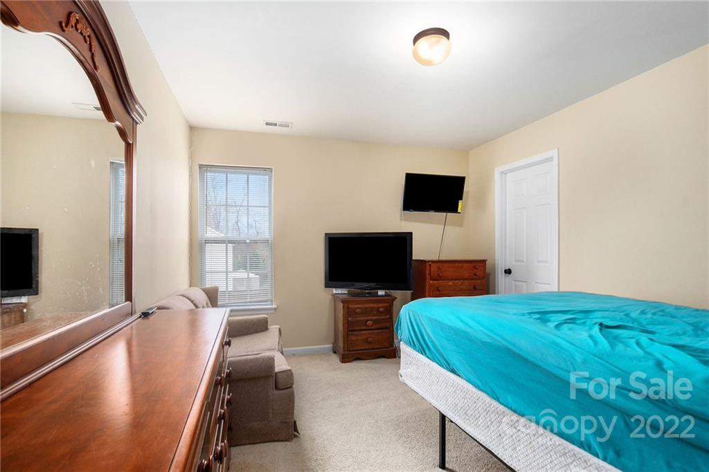 1222 Ben Livingston Road Charlotte, NC 28214 - Photo 25 of 32 a bedroom with a bed and a flat tv screen on the dresser