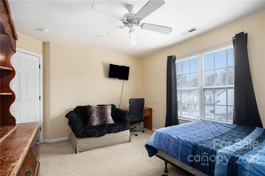 1222 Ben Livingston Road Charlotte, NC 28214 - Photo 29 of 32 a bedroom with a bed and a chair