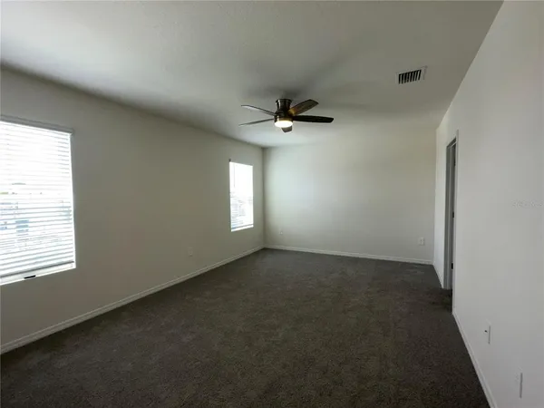 an empty room with a window and a fan