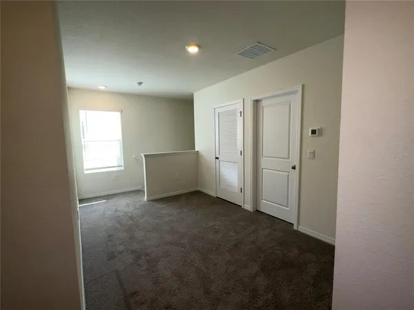 an empty room with windows and closet