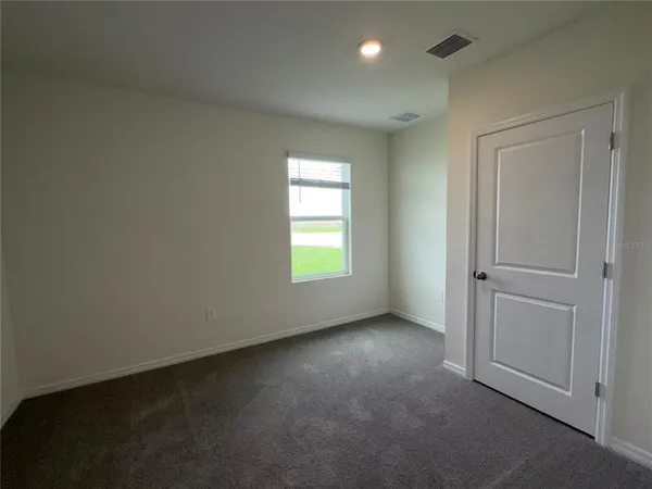 an empty room with windows and closet