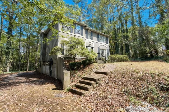 a view of a yard with plants and trees