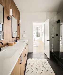 a bathroom with a double vanity sink a mirror and a shower